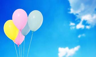 blaue, rosa, gelbe Luftballons auf verschwommenem Himmelshintergrund, Textfreiraum, Feiertage, Feier foto