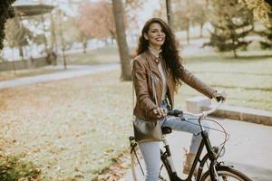 junge Frau, die am Herbsttag Fahrrad fährt foto