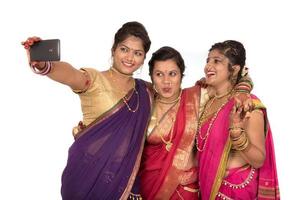 Indische traditionelle Mädchen machen Selfie mit Smartphone auf weißem Hintergrund foto