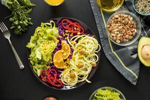 Draufsicht garniert gesunder Salatteller mit Driftgabel vor schwarzem Hintergrund