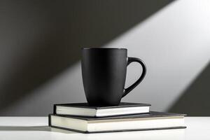 schwarz Tasse auf Bücher im Sonnenlicht auf grau Hintergrund foto