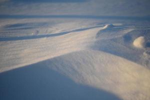 verschneite Landschaften und Schneenahaufnahme in Sonnenstrahlen. Gras und Gegenstände im Schnee. foto