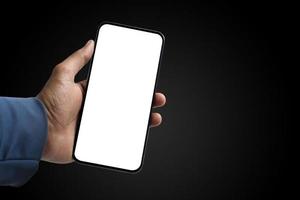 Smartphone in der Hand auf dunklem Hintergrund halten foto