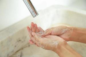 Reinigung der Hände mit Seife im Waschbecken für den Lebensstil des Gesundheitswesens foto