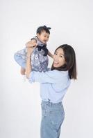 asiatische Mutter und entzückendes Baby sind glücklich auf weißem Hintergrund foto