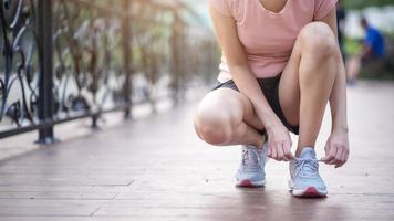 Nahaufnahme Frau Schuhe im Park binden foto