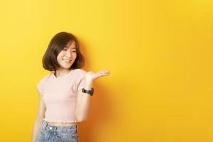 schöne asiatische Studentin glücklich auf gelbem Hintergrund foto