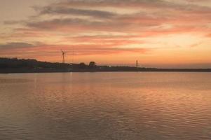 ein Hintergrund von Windkraftanlagen bei Sonnenuntergang. foto