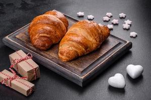 leckere frische knusprige Croissants auf dunklem Betongrund foto