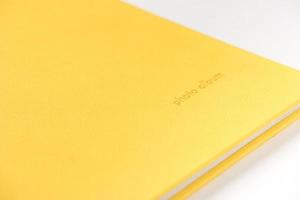 gelbes Hardcover-Fotoalbum auf weißem Hintergrund. Nahansicht foto