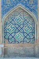 Wand mit einem Bogen im traditionellen asiatischen Mosaik. die Details der Architektur des mittelalterlichen Zentralasiens foto