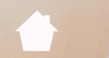 weiße Hausform gesprüht auf braunem Papier Obdachlosenwohnungs- und Hausschutzversicherungskonzept, internationaler Tag der Familien, Pflege zu Hause und Immobilien. foto