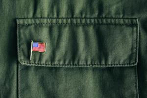 USA-Flagge-Pin-Abzeichen auf grüner Jackentasche foto
