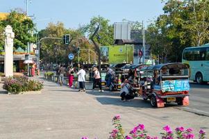 chiang mai thailand10 januar 2020eine gruppe von touristen, die ein tuktuk-auto nehmen, steigt aus dem bus, um in chiang mai zu reisen. Tuktuks-Autos sind an vielen Reisezielen in Thailand erhältlich. foto