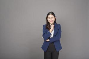 Porträt der schönen brünetten Geschäftsfrau auf grauem Hintergrundstudio foto