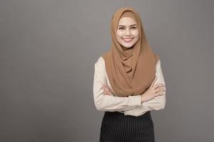 Porträt der schönen Frau mit Hijab lächelt auf grauem Hintergrund