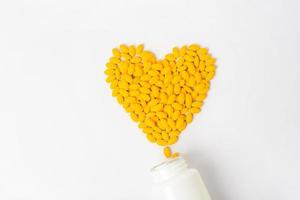 Haufen von gelben Vitamintabletten auf weißem Hintergrund foto