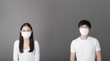 Porträt von Mann und Frau mit chirurgischer Maske im Studio, Konzept der sozialen Distanzierung foto