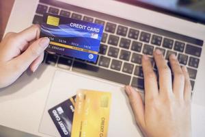 Frauenhand hält Kreditkarte und kauft online ein