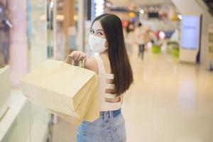 Porträt der schönen Frau trägt Gesichtsmaske im Einkaufszentrum