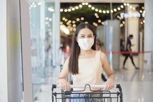 Porträt der schönen Frau trägt Gesichtsmaske im Einkaufszentrum