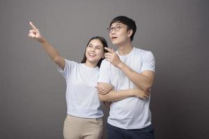 ein Porträt eines glücklichen Paares, das blaues Hemd trägt, genießt über grauem Hintergrundstudio foto