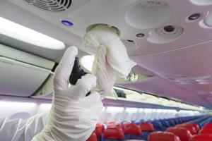 Nahaufnahme Hand trägt Handschuhe, die Flugzeuge für die Covid-19-Präventionspandemie reinigen foto