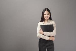 Porträt einer schönen Geschäftsfrau, die auf grauem Hintergrund lächelt foto