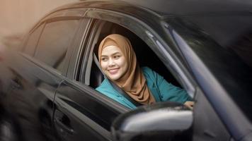 schöne Geschäftsfrau mit Hijab lächelt in ihrem Auto foto