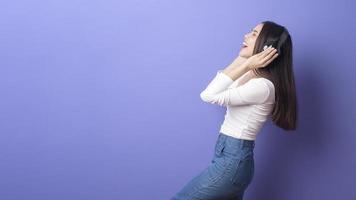 junge Frau hört Musik auf lila Hintergrund foto