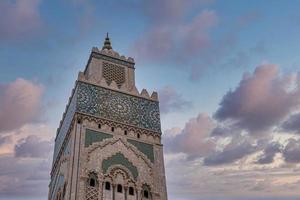 Flachwinkelansicht der historischen Moschee Hasan II mit dem höchsten Minarett gegen den Himmel foto