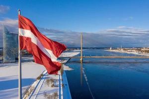 Panoramablick auf die Stadt Riga mit einer großen lettischen Flagge am Fluss Daugava. lettischer Geist. foto