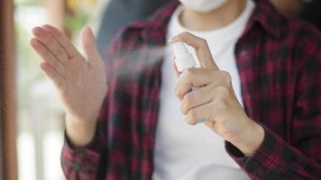 Nahaufnahme der Frauenhand verwendet Alkoholspray zum Schutz vor Covid-19 foto