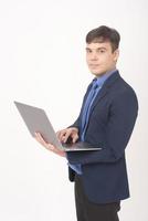 Porträt des jungen Geschäftsmannes benutzt einen Laptop über weißem Hintergrundstudio foto