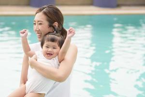 eine glückliche asiatische mutter und tochter genießen es, im pool zu schwimmen, lebensstil, elternschaft, familienkonzept foto