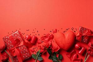 Valentinstaggeschenke, Rosen und Kerzen auf rotem Hintergrund, Kopienraum foto