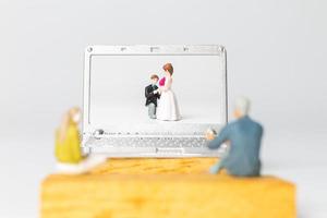 Miniatur Menschen Braut und Bräutigam virtuelle Hochzeit auf dem Computerbildschirm foto