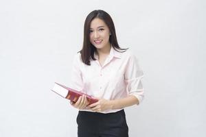 Porträt der schönen Studentin im rosa Hemd hält ein Buch isoliert auf weißem Hintergrund Studio foto