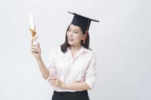 ein Porträt der schönen jungen asiatischen Frau mit Bildungskappe über weißem Hintergrundstudio, Bildungskonzept. foto