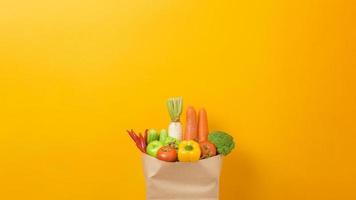 Gemüse in Einkaufstüte auf gelbem Hintergrund foto