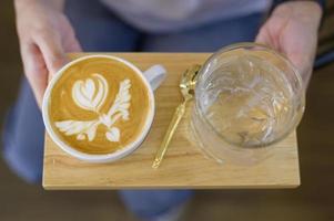 Draufsicht einer Tasse heißer Latte Art auf Holztischhintergrund