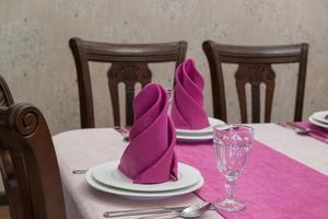 Banketttisch in einem luxuriösen Restaurant im rosa-weißen Stil servieren foto