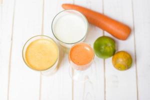 gesunde Ernährung Obst- und Gemüsesaft trinkfertig auf Holztisch foto