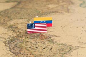Flaggen der USA und Venezuelas auf der Weltkarte. Konzeptfoto, Politik und Weltordnung foto