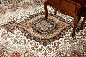 antiker Tisch auf dem dekorierten Orientteppich foto