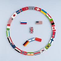 Abbildung eines Smileys von Nationalflaggen auf Dominosteinen. Konzept des Friedens und des Gemeinwesens der Nationen und der Weltordnung foto