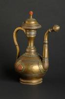 alte orientalische Teekanne aus Metall auf dunklem Hintergrund. antikes Bronzegeschirr
