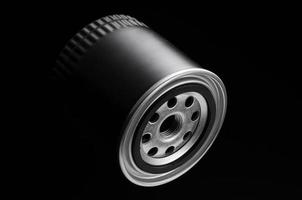 metallischer Automobilfilter zylindrische Form auf schwarzem Hintergrund foto