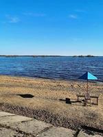 Strandkörbe am weißen Sandstrand mit bewölktem blauen Himmel und Sonne. foto