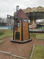 dekorative Windmühle aus Holz in einem Vergnügungspark.Wege und grünes Gras im Park.Erholung, Kinder, Spaß, Unterhaltung foto